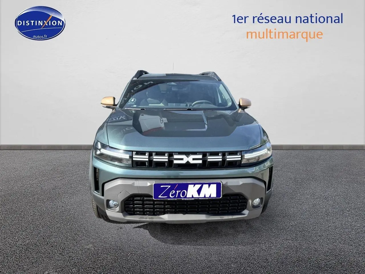 Vue frontale d'un Dacia Duster 2025 vert cèdre avec calandre noire et rétroviseurs couleur carrosserie.