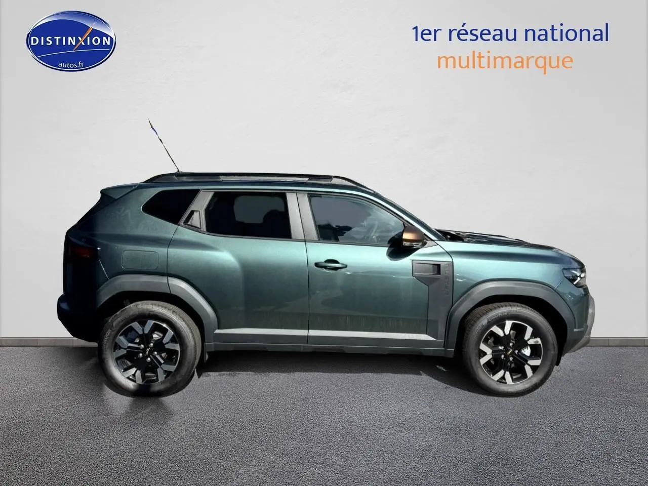 Profil droit d'un Dacia Duster 2025 vert cèdre avec jantes alu et barres de toit visibles sur fond neutre.