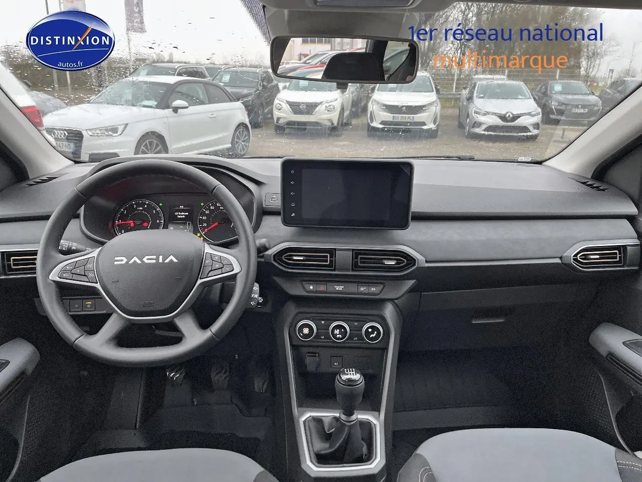 Vue intérieure frontale du tableau de bord et volant noir du Dacia Jogger 2025 avec écran tactile et boîte manuelle.