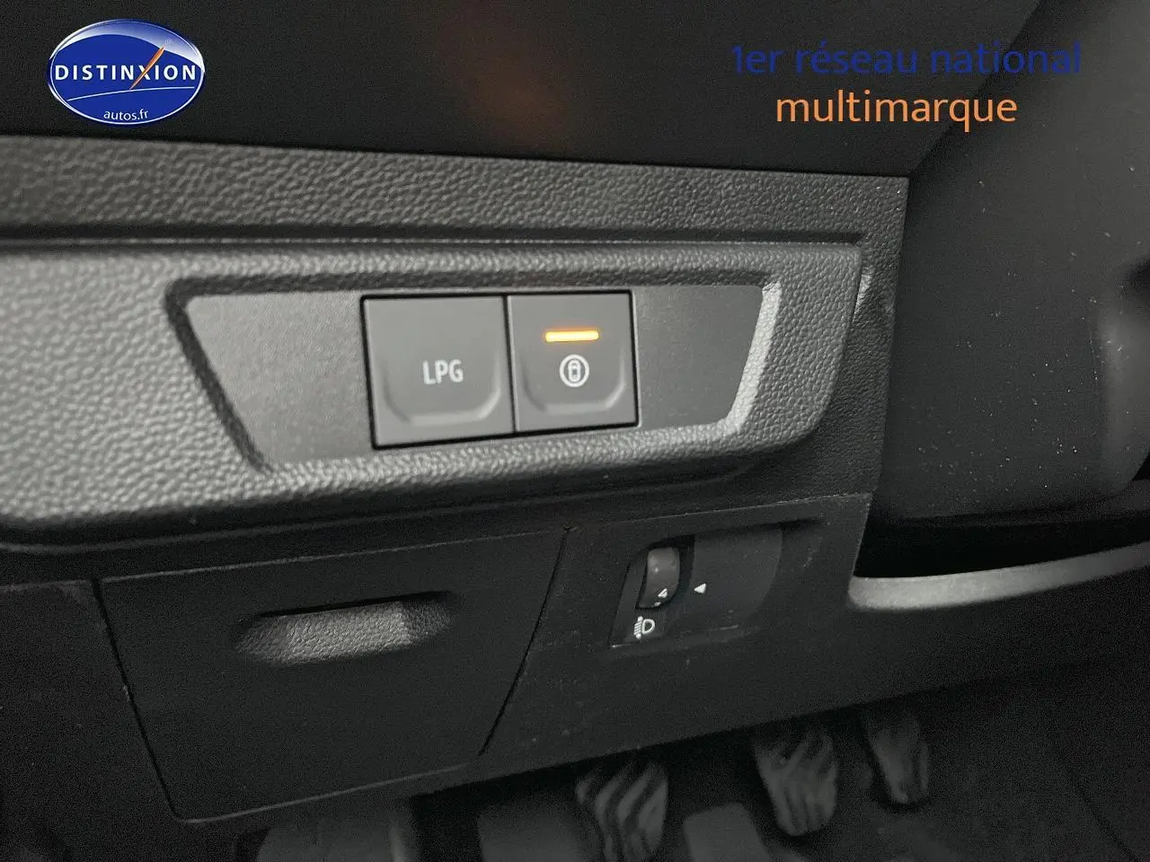 Gros plan sur les commandes LPG et verrouillage, côté conducteur du tableau de bord noir du Dacia Jogger blanc 2025.