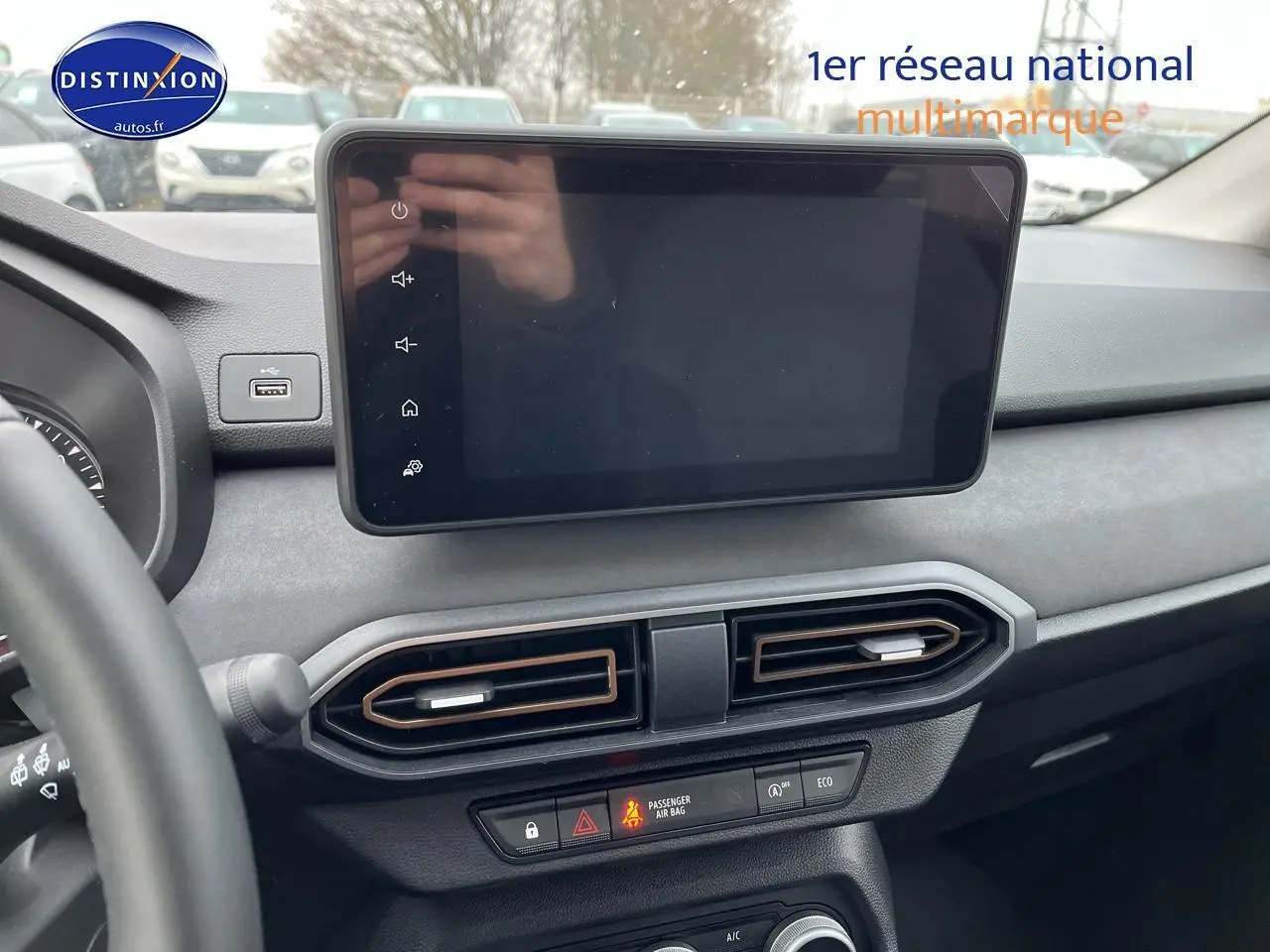 Vue intérieure du tableau de bord de la Dacia Jogger blanche 2025, avec écran tactile et aérateurs centraux noirs.