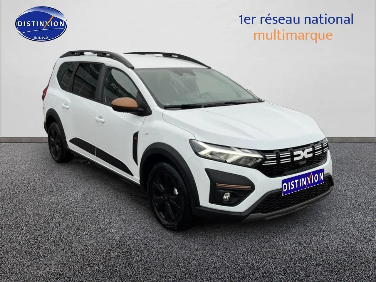 Vue 3/4 avant droite du Dacia Jogger blanc avec jantes noires et rétroviseurs couleur bronze.