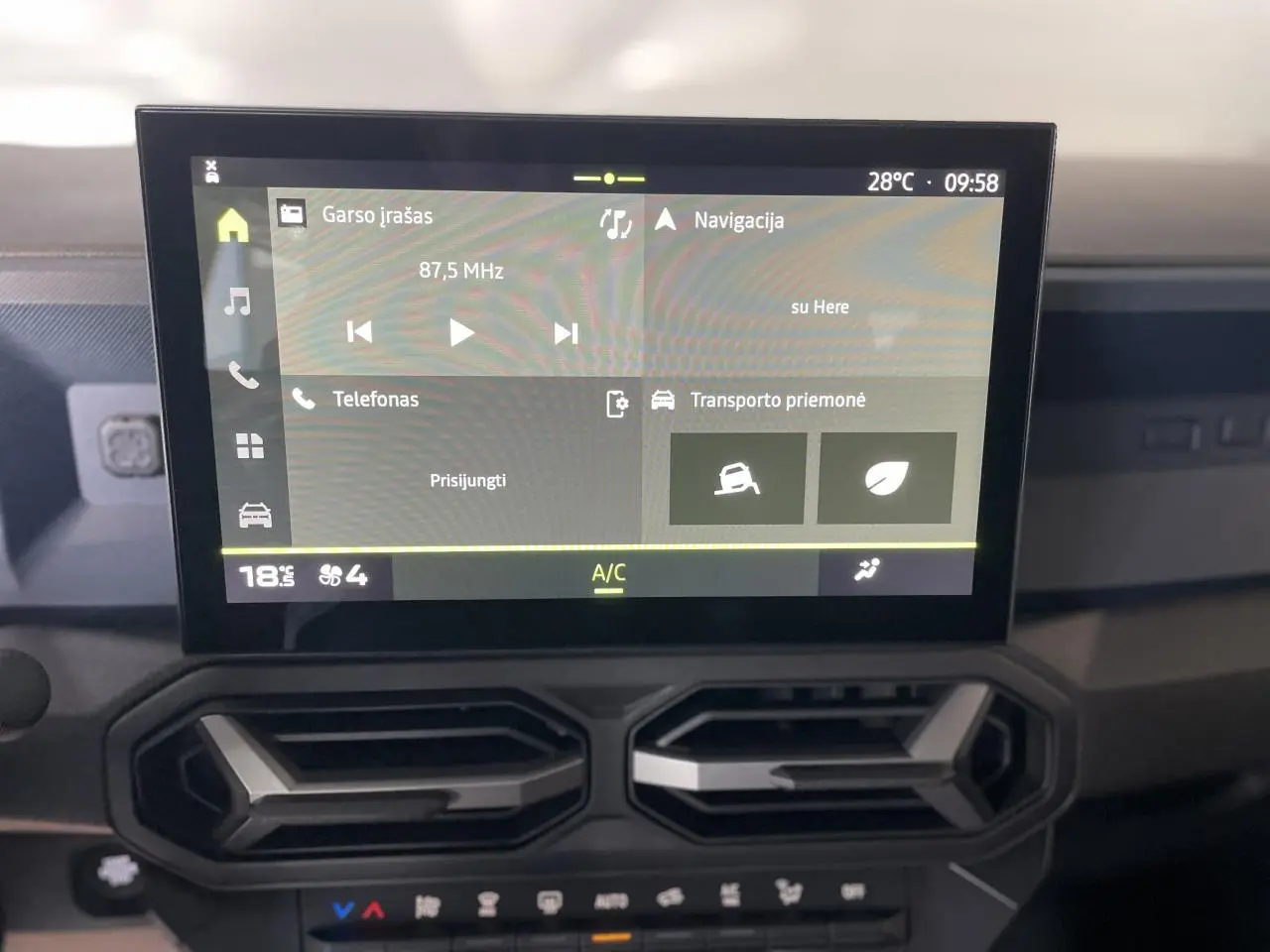 Vue rapprochée de l’écran tactile central et des aérateurs gris acier du tableau de bord du Dacia Duster beige 2025.