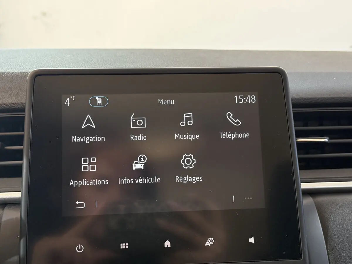 Écran tactile central du tableau de bord du Renault Captur bleu, affichant le menu principal multimédia.