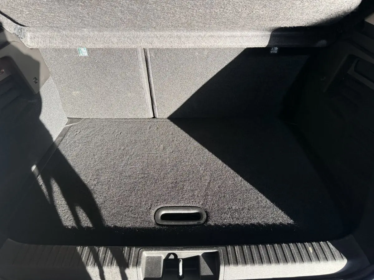 Coffre spacieux et propre du Renault Captur bleu, vue intérieure depuis l'arrière avec banquette rabattue.