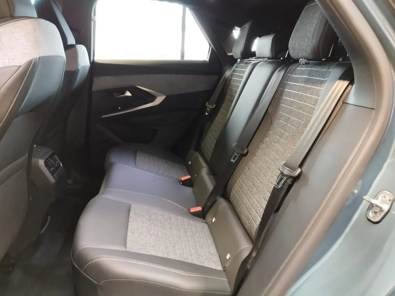 Vue intérieure côté droit des sièges arrière en tissu gris et noir du Peugeot 3008 Bleu Azul 2025.