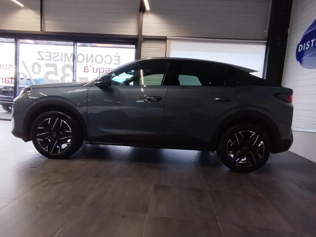 Profil côté gauche du Peugeot 3008 2025 bleu métallisé avec jantes alliage noires et vitres teintées.