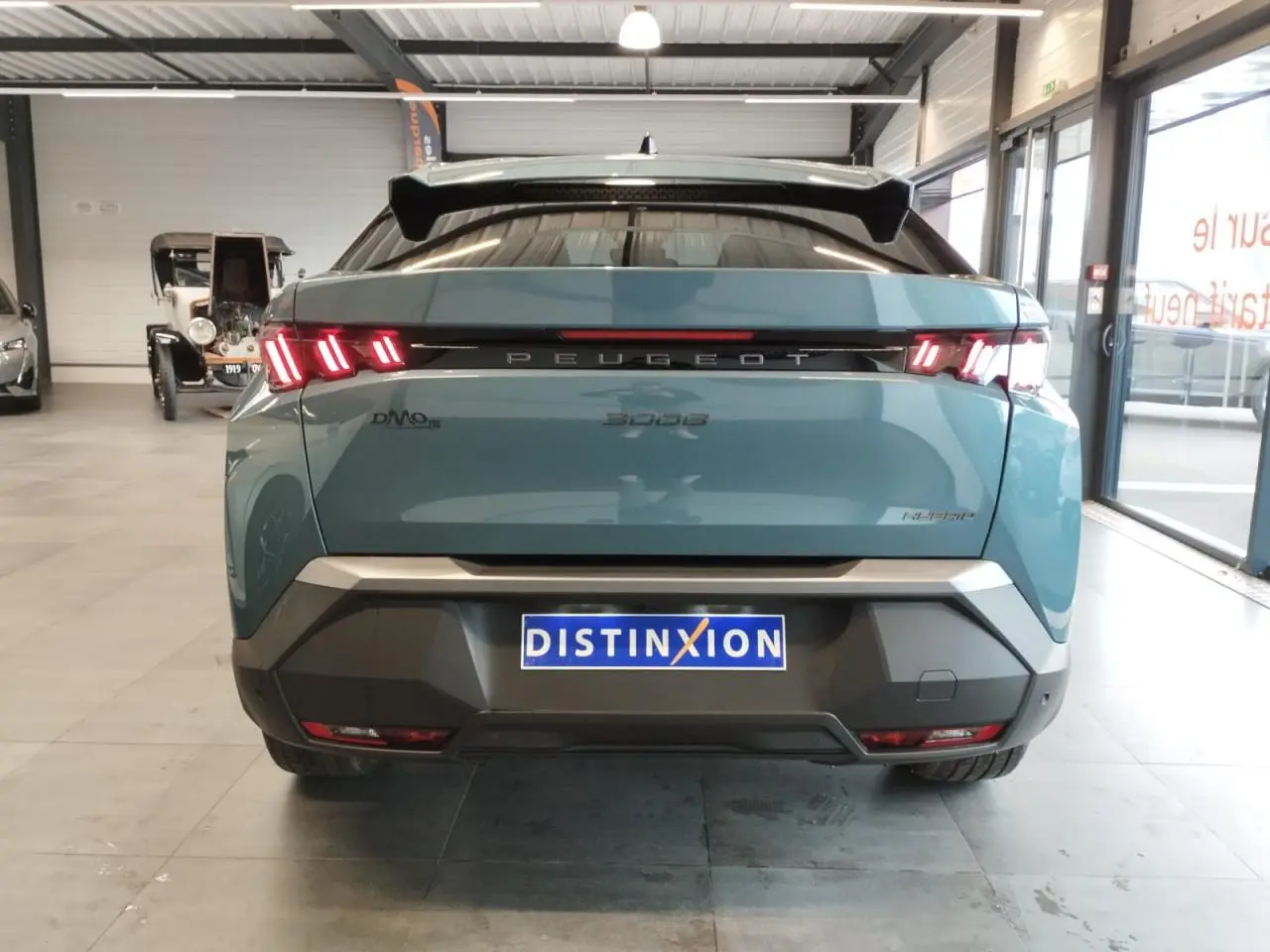 Vue arrière d'un Peugeot 3008 hybride bleu Azul avec feux arrière à LED 3 griffes et bandeau noir laqué.