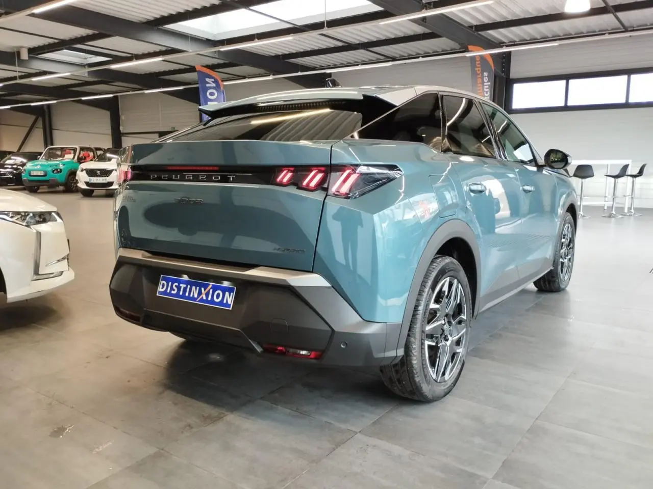 Vue 3/4 arrière droite d’un Peugeot 3008 hybride bleu métallisé avec feux arrière à LED en forme de griffes.