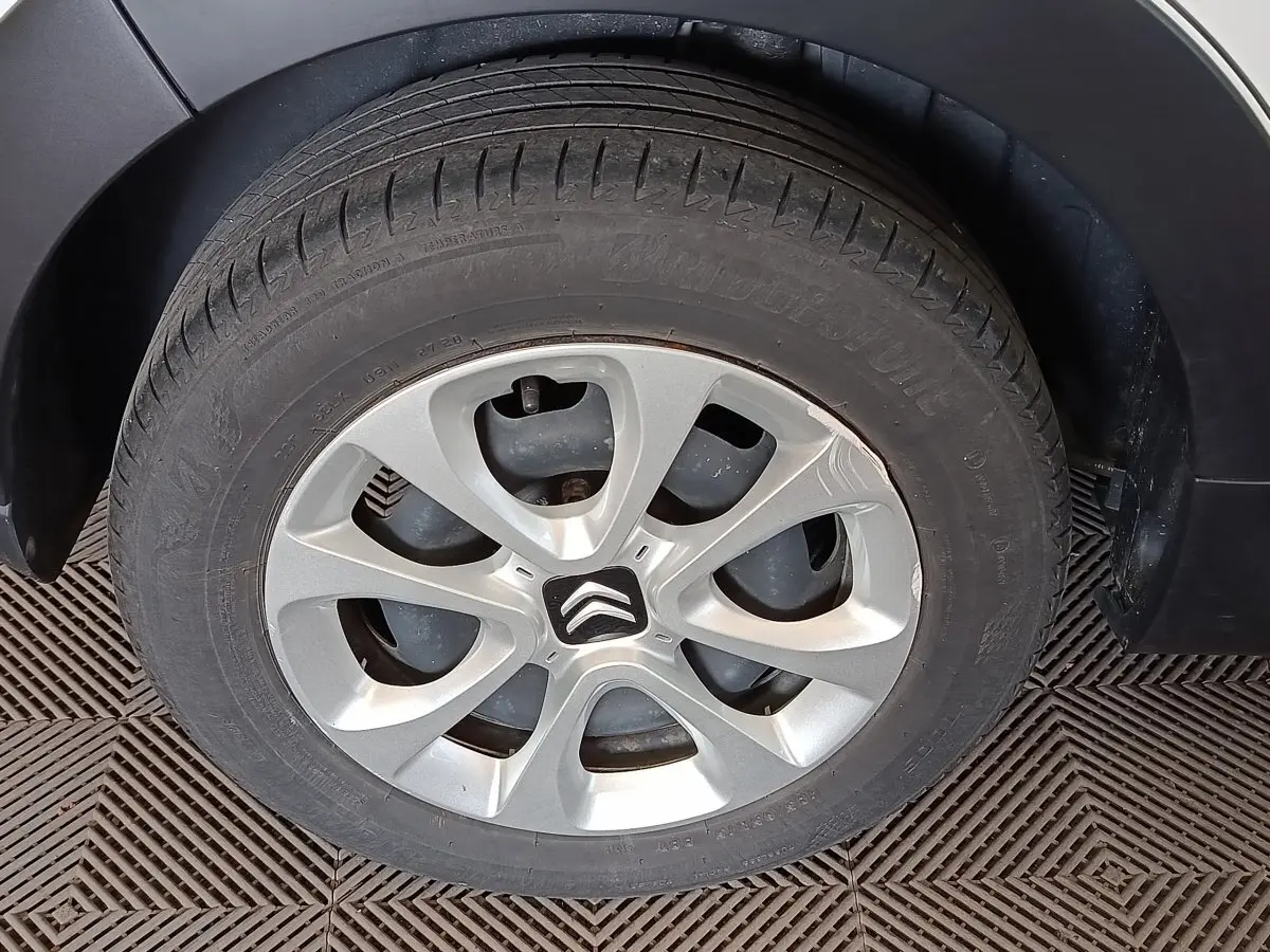 Gros plan sur la roue arrière droite d'une Citroën C3 blanche, avec jante alliage et passage de roue noir.