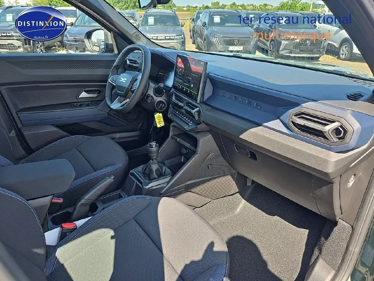 Intérieur du Dacia Duster 2025 vert kaki, vue côté conducteur montrant tableau de bord moderne et volant multifonction.