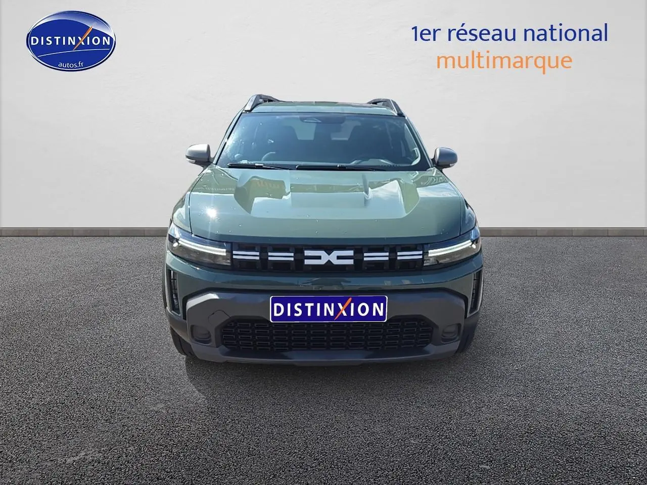 Vue de face d'un Dacia Duster 2025 vert kaki avec calandre moderne et barres de toit visibles.