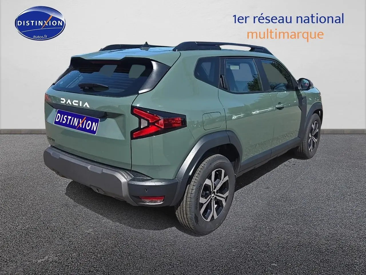 Vue 3/4 arrière droite du Dacia Duster vert kaki 2025 avec barres de toit et jantes alu noires.