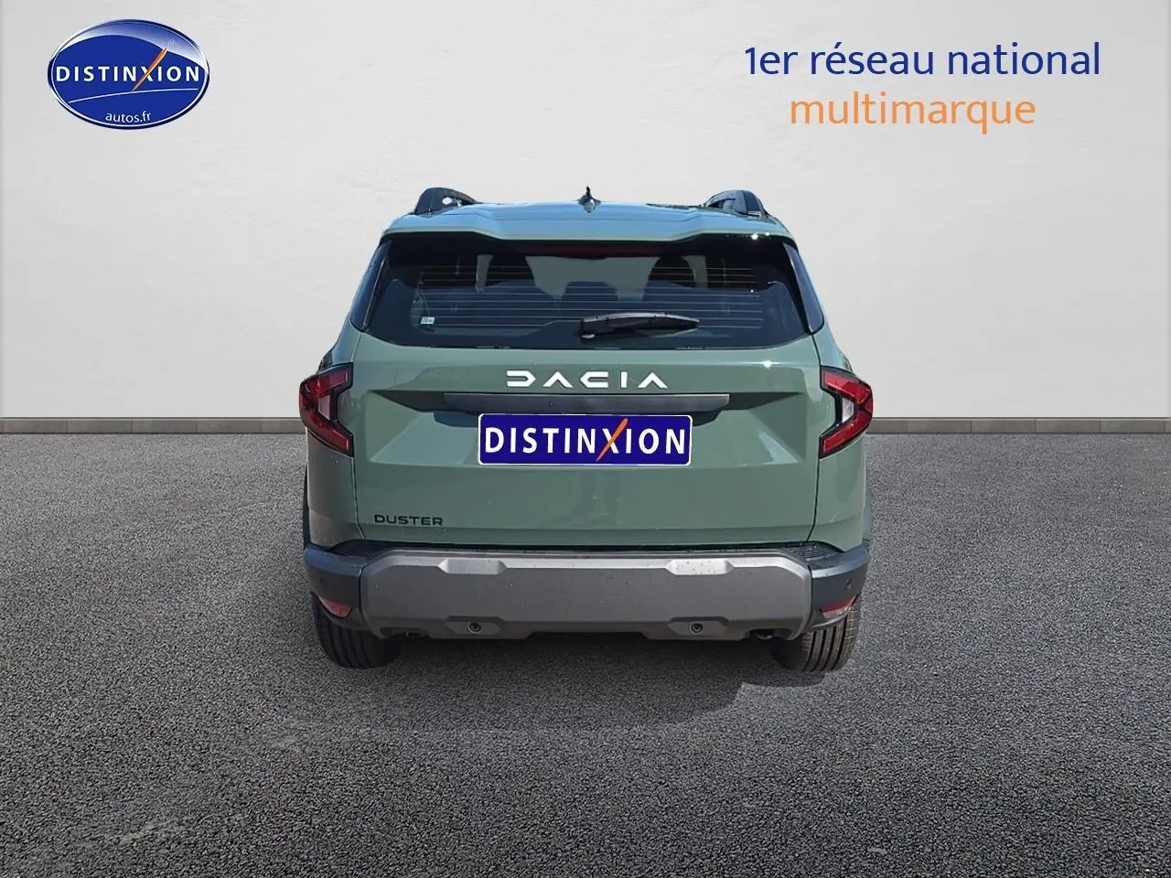 Vue arrière du Dacia Duster vert kaki 2025 avec bouclier gris et barres de toit visibles sur fond neutre.