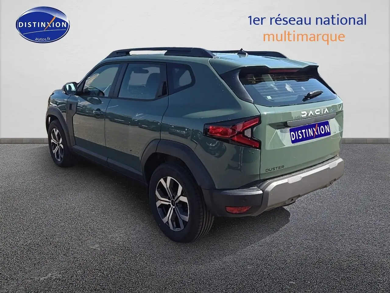 Vue 3/4 arrière droite du Dacia Duster 2025 vert kaki avec barres de toit et jantes alu.