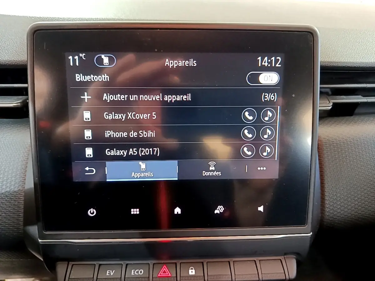 Écran tactile central de la Renault Clio Business E-TECH 140 gris foncé, affichant menu Bluetooth et appareils connectés.