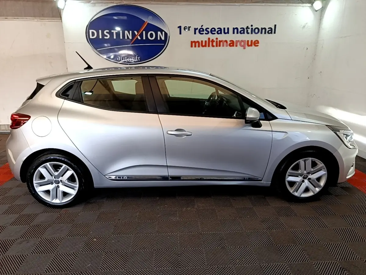 Profil droit de la Renault Clio Business E-TECH 140 gris foncé, avec jantes alliage et logo Clio visible sur la porte.