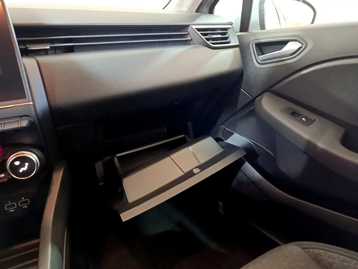 Intérieur de la Renault Clio Business E-TECH 2022, vue côté passager montrant la boîte à gants ouverte et tableau de bord gris foncé.