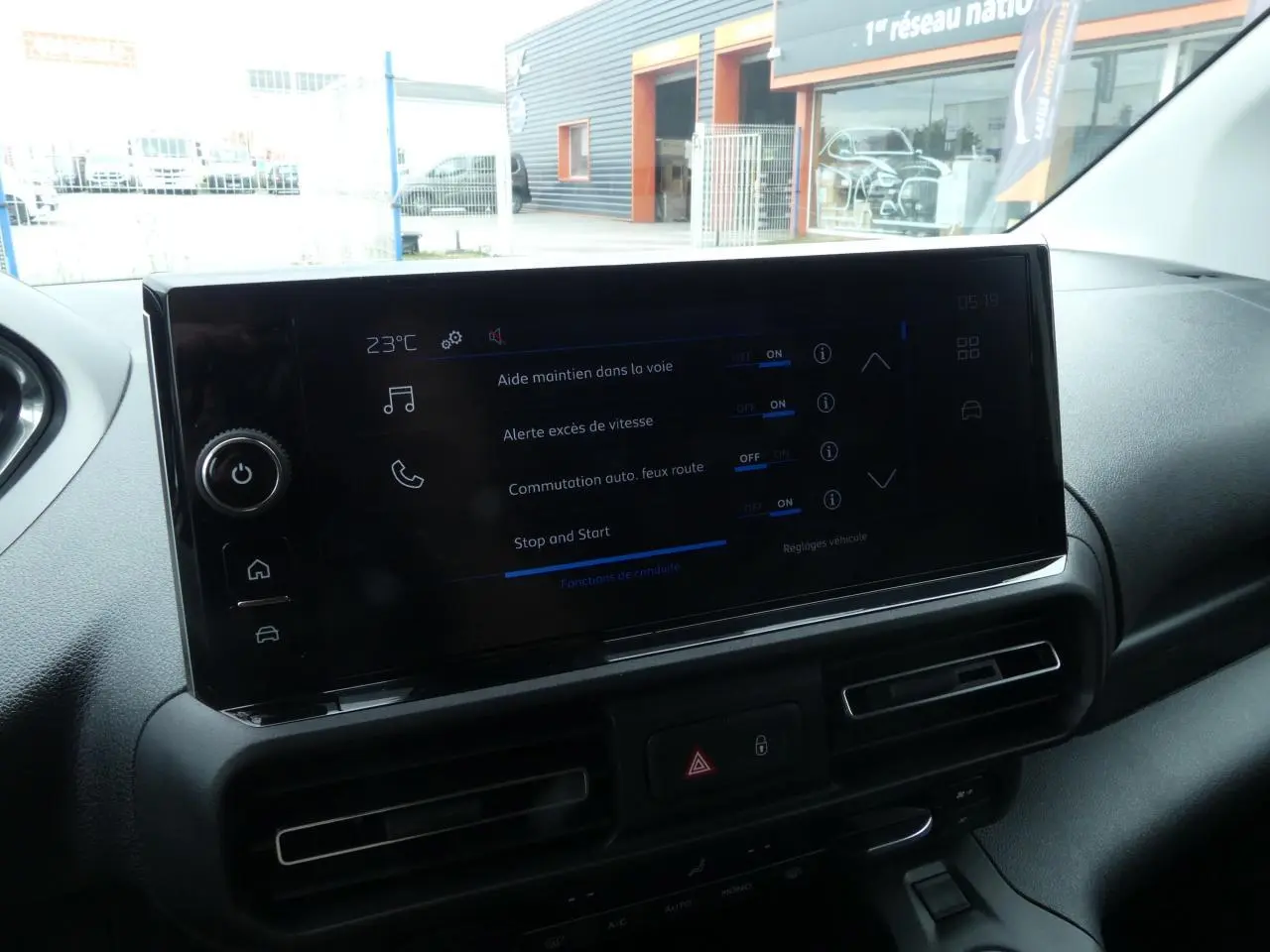 Écran tactile central du tableau de bord du Peugeot Partner blanc, vue intérieure avant droite.