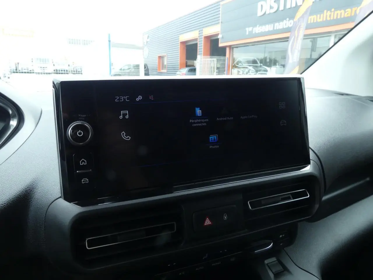 Vue intérieure du tableau de bord du Peugeot Partner blanc, avec écran tactile 10 pouces et commandes de climatisation.