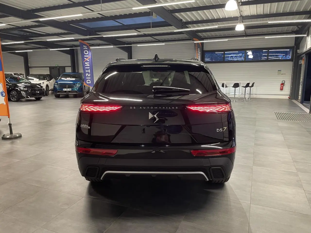 Vue arrière du DS7 Crossback noir métallisé avec feux arrière LED 3D et logo DS Automobiles éclairé.