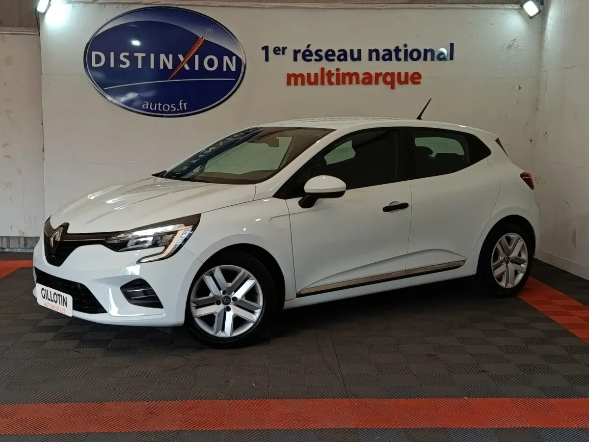 Renault Clio Business blanche vue de profil droit en intérieur, avec jantes alliage et feux LED allumés.