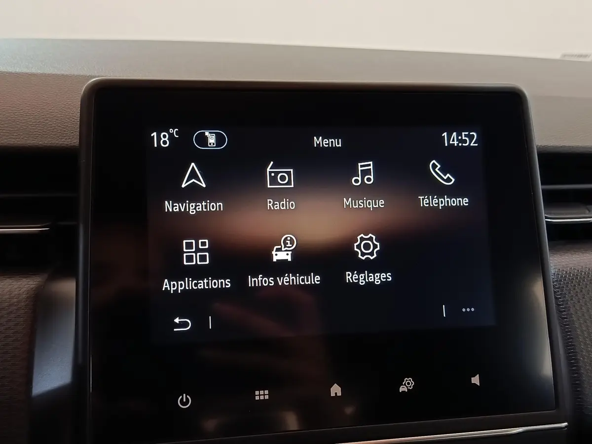 Écran tactile central de la Renault Clio Business blanc, affichant le menu principal avec navigation et radio.