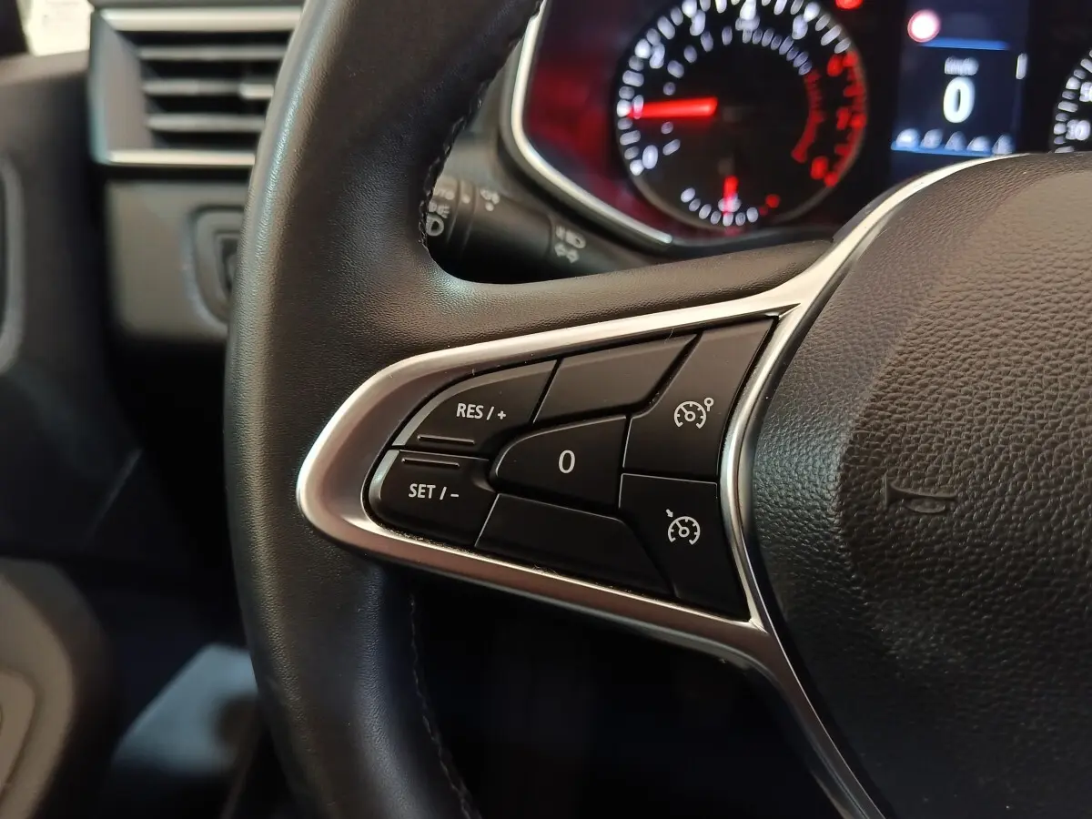 Gros plan sur le volant cuir synthétique noir de la Renault Clio Business 2021, avec commandes multifonctions côté gauche.