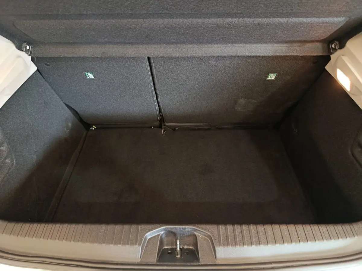 Coffre vide de Renault Clio Business blanc, vue plongeante montrant l'espace de chargement et la banquette arrière rabattable.