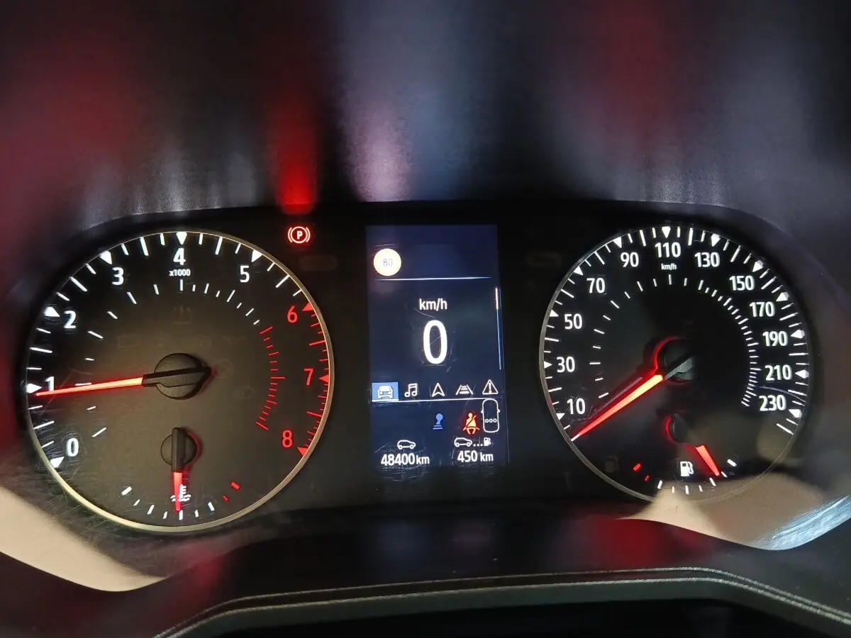 Tableau de bord de Renault Clio Business blanc 2021, affichage numérique central et compteurs analogiques éclairés rouge.