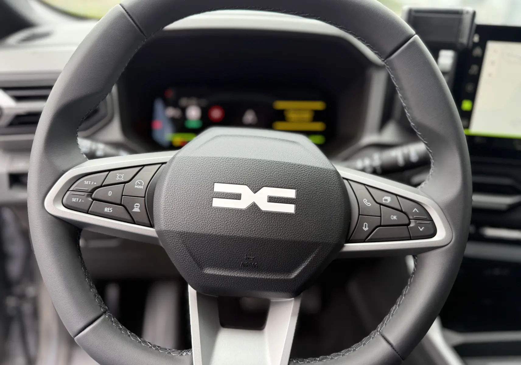 Vue rapprochée du volant noir du Dacia Bigster 2026 avec commandes intégrées et logo central distinctif.