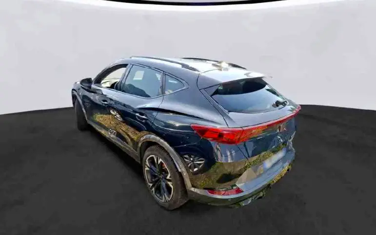 Vue 3/4 arrière droite d'une CUPRA Formentor noire 2024 avec feux arrière reliés et jantes noires distinctives.