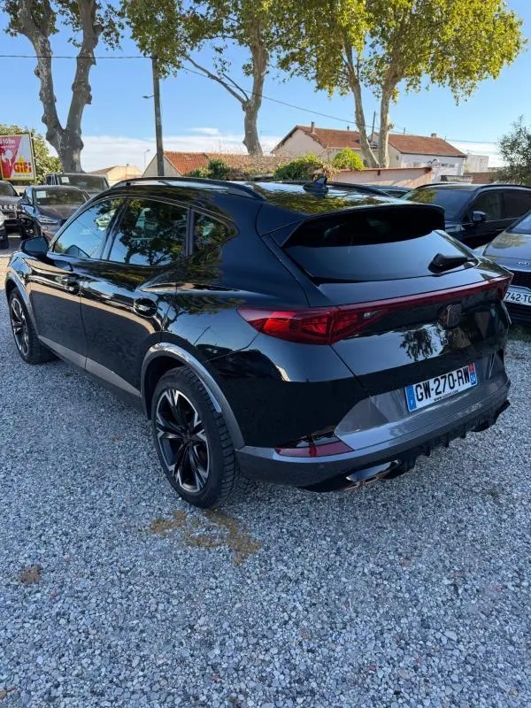 Vue 3/4 arrière droite d'un CUPRA Formentor noir 2024 avec feux arrière allongés et jantes noires distinctives.