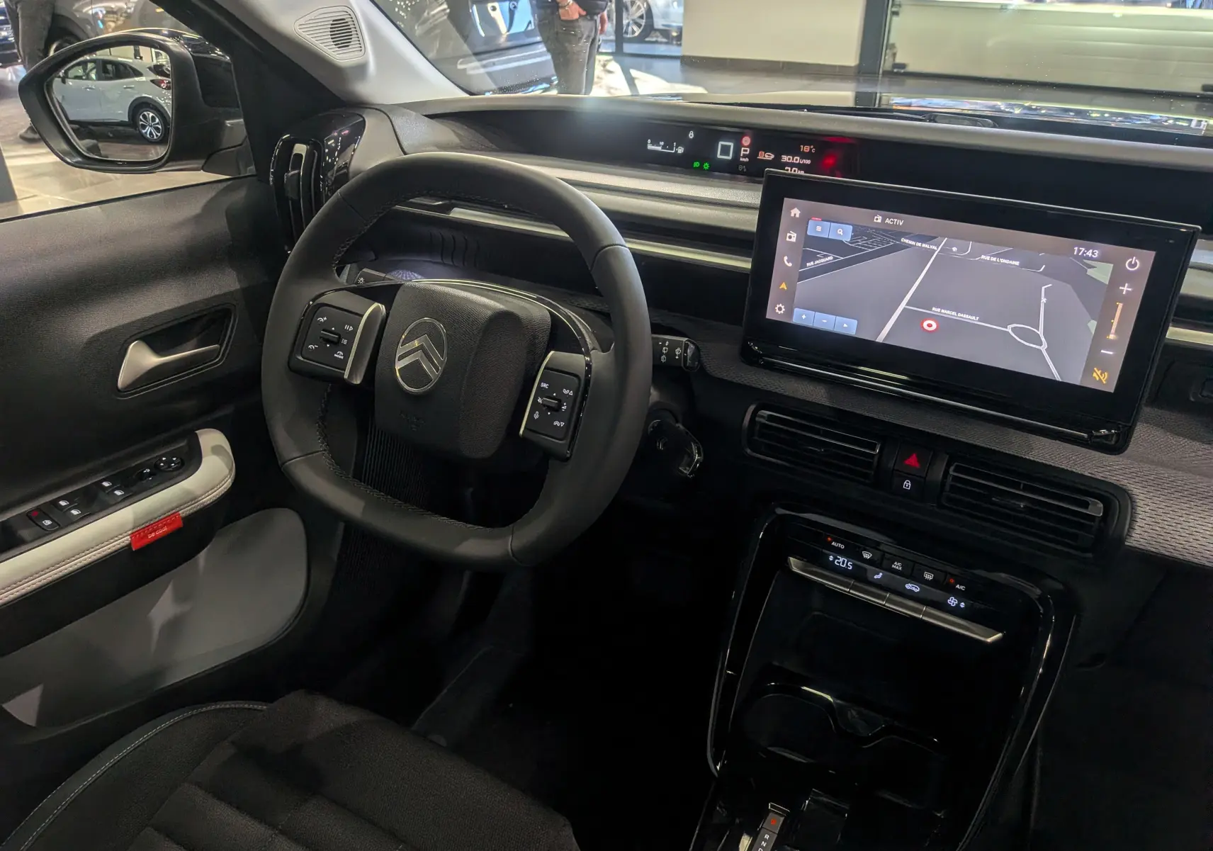 Intérieur du Citroën C3 Aircross hybride 2025, vue côté conducteur sur volant, écran tactile et tableau de bord numérique.