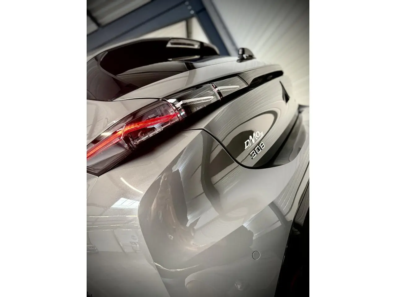 Gros plan arrière droit de la Peugeot 308 GT gris selenium avec feux arrière LED et logo distinctif DN08.