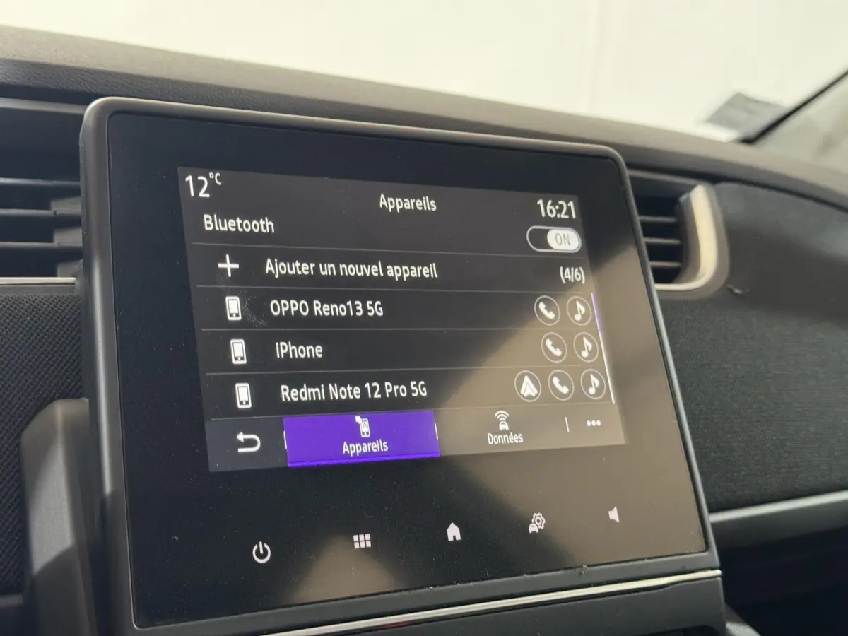 Écran tactile central de la Renault ZOE Business blanc, affichant la connexion Bluetooth des appareils.