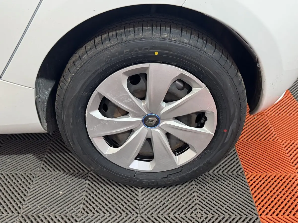 Gros plan sur la roue avant gauche blanche d'une Renault ZOE 2020 avec enjoliveur argenté et logo Renault central.