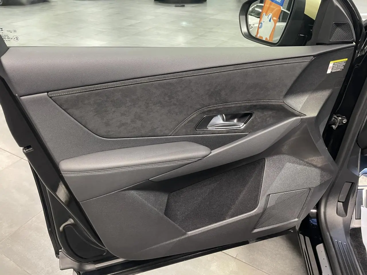 Vue intérieure côté gauche de la porte avant noire métallisée du DS7 Crossback avec garniture Alcantara et surpiqûres.