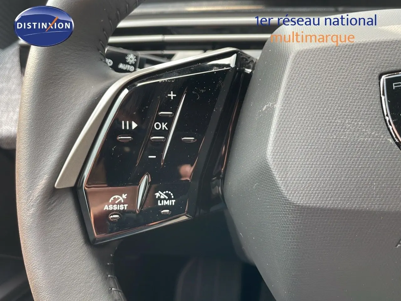 Gros plan sur les commandes gauche du volant du Peugeot 3008 Hybrid gris Artense, avec boutons de régulateur et limiteur de vitesse.