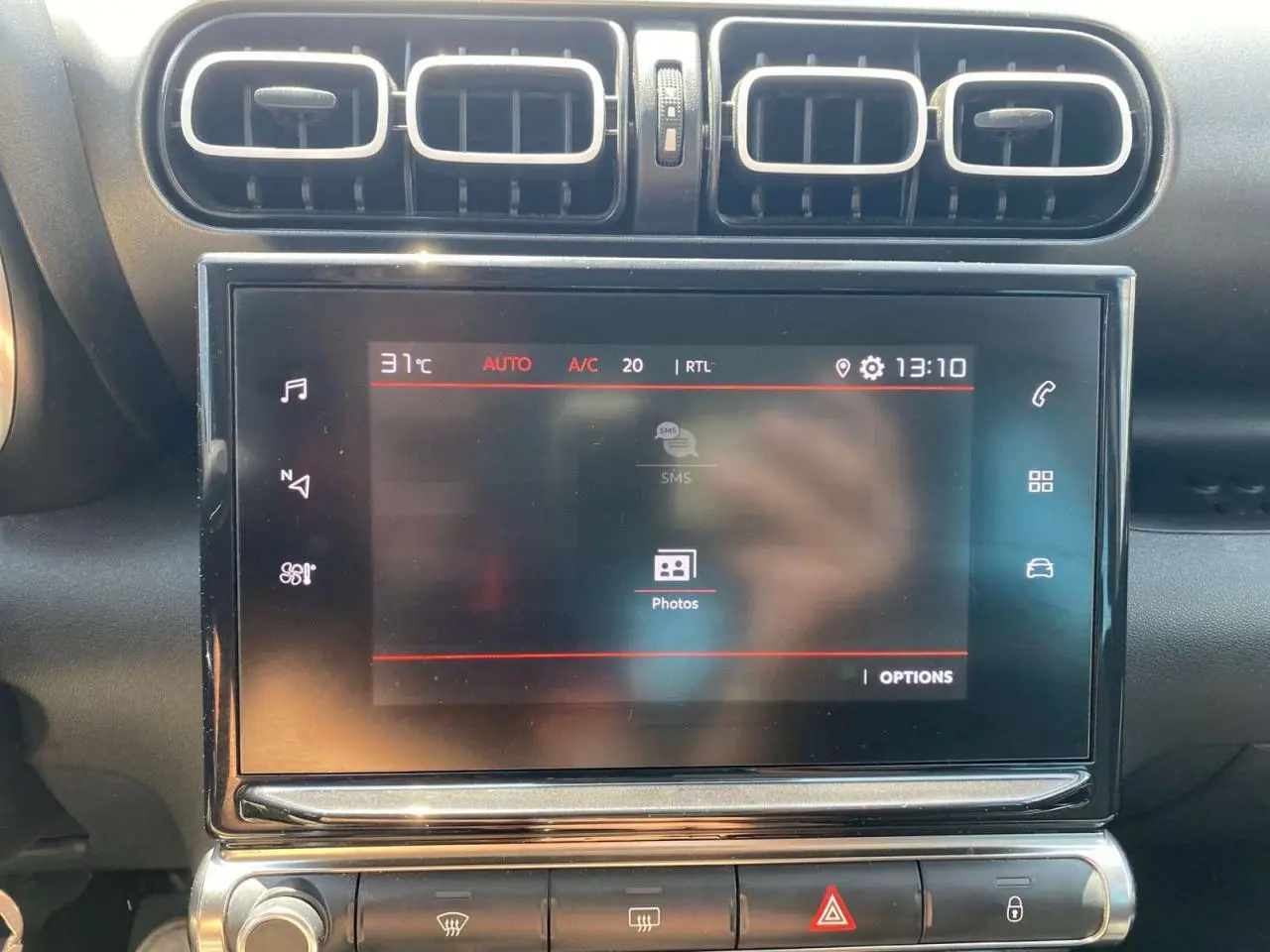 Écran tactile central allumé avec commandes climatisation et aérateurs rectangulaires dans l'habitacle d'une Citroën C3 Aircross 2023.