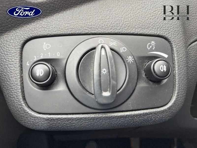 Gros plan sur le commutateur d'éclairage du Ford Kuga 2.0 TDCi 150ch Titanium de 2015, finition noire texturée.