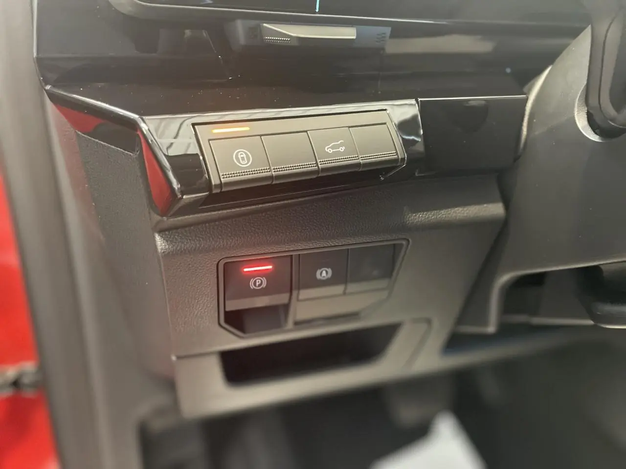 Détail intérieur côté gauche avec commandes électroniques et partie de la carrosserie rouge du Renault Rafale 2025.