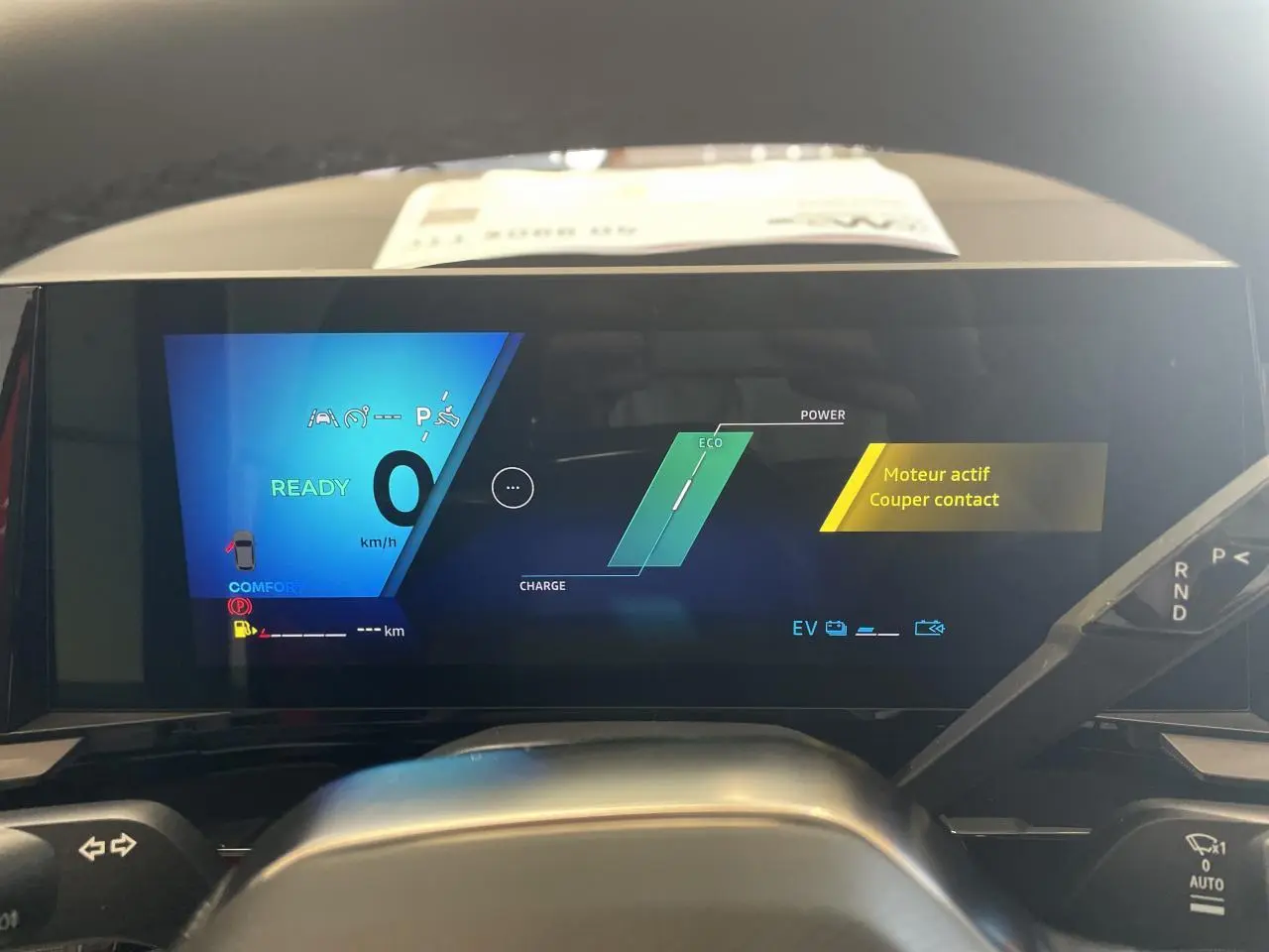 Vue de face du tableau de bord numérique de la Renault Rafale rouge, affichant l'état moteur et mode Eco.