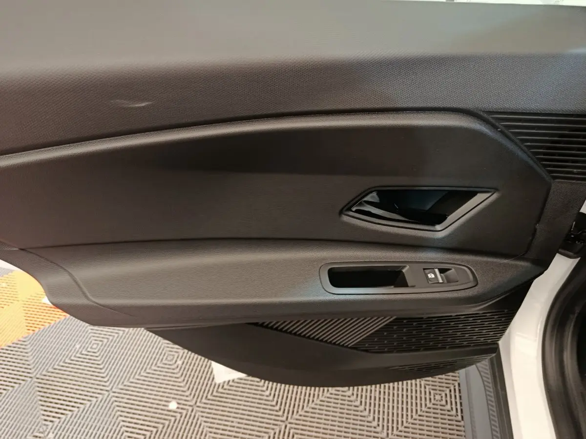 Vue intérieure du panneau de porte avant droite noire d'une Renault R5 Techno 150 ch électrique blanche 2025.