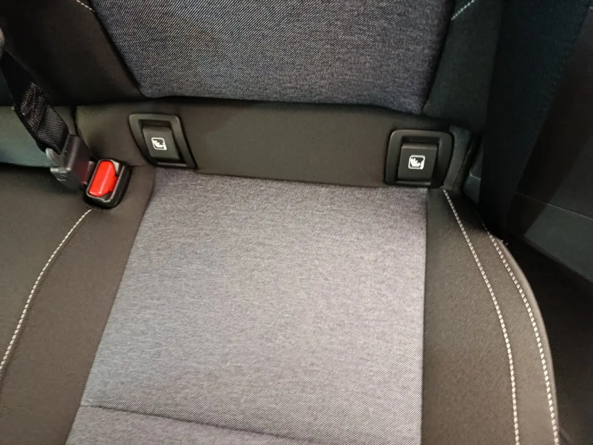 Détail de la banquette arrière grise avec fixation Isofix et ceinture rouge dans une Renault R5 Techno 2025.