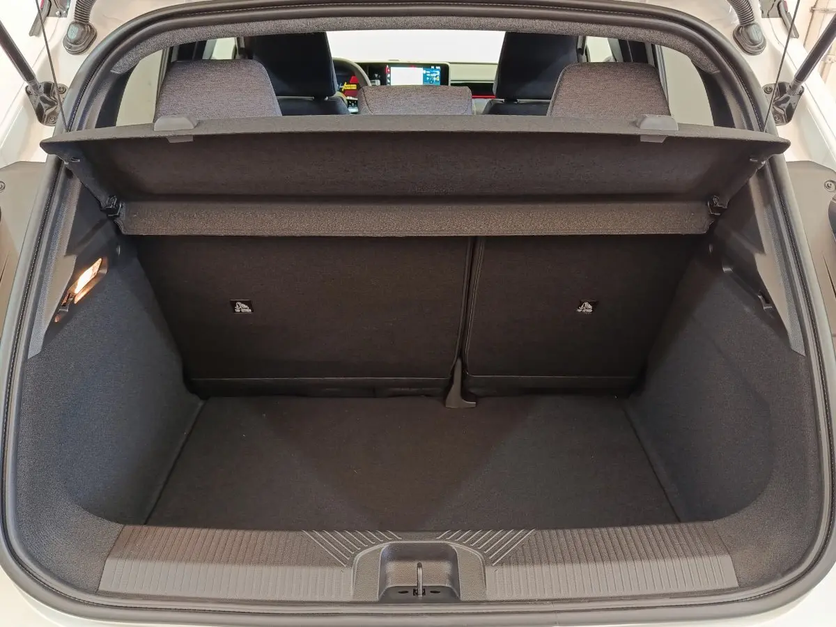 Vue du coffre arrière ouvert d'une Renault R5 Techno 150 ch blanc, avec banquette arrière rabattable 2/3-1/3 visible.