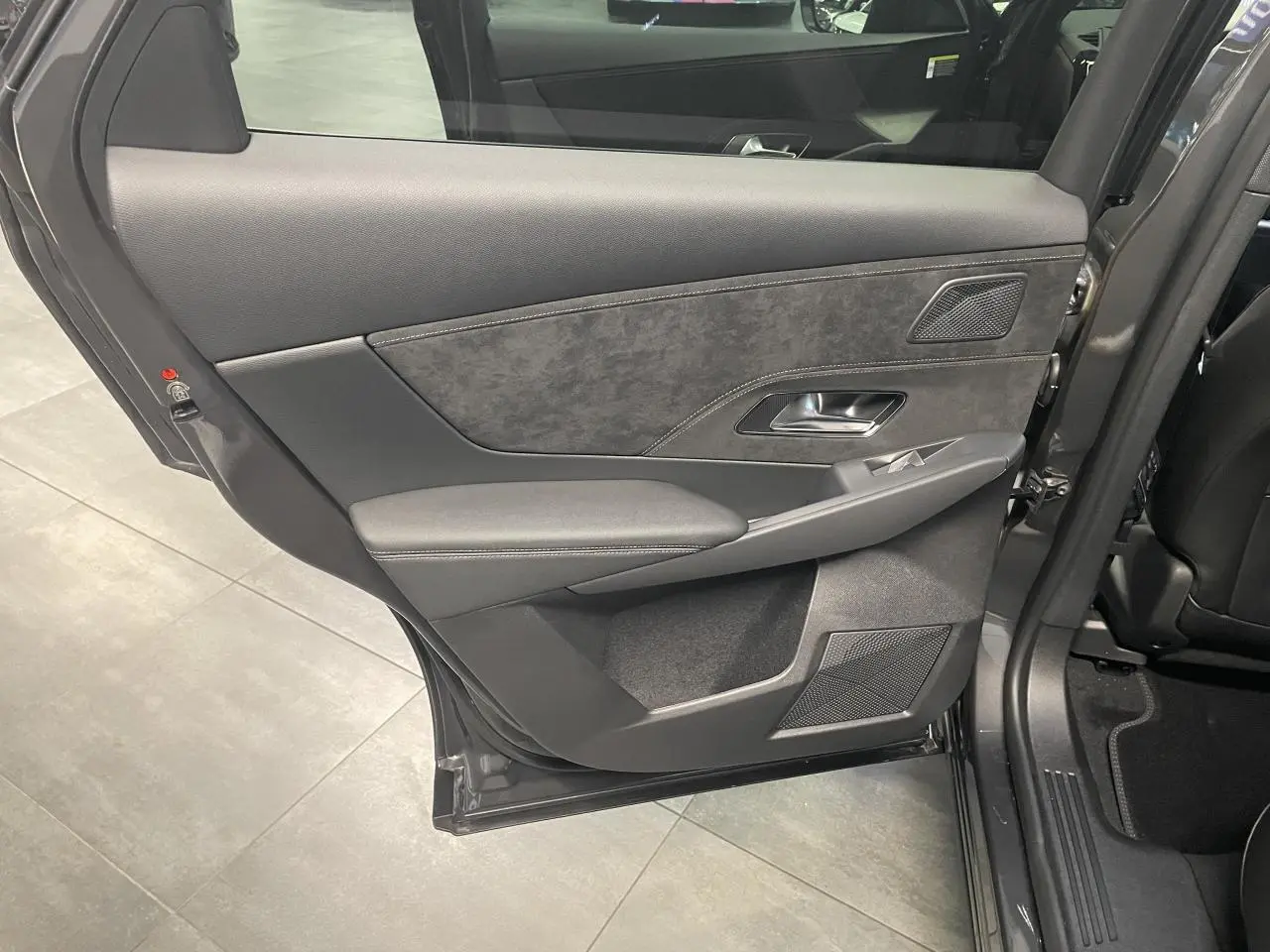 Vue rapprochée de la porte arrière gauche gris titanium du DS7 Crossback avec habillage Alcantara et commandes électriques.