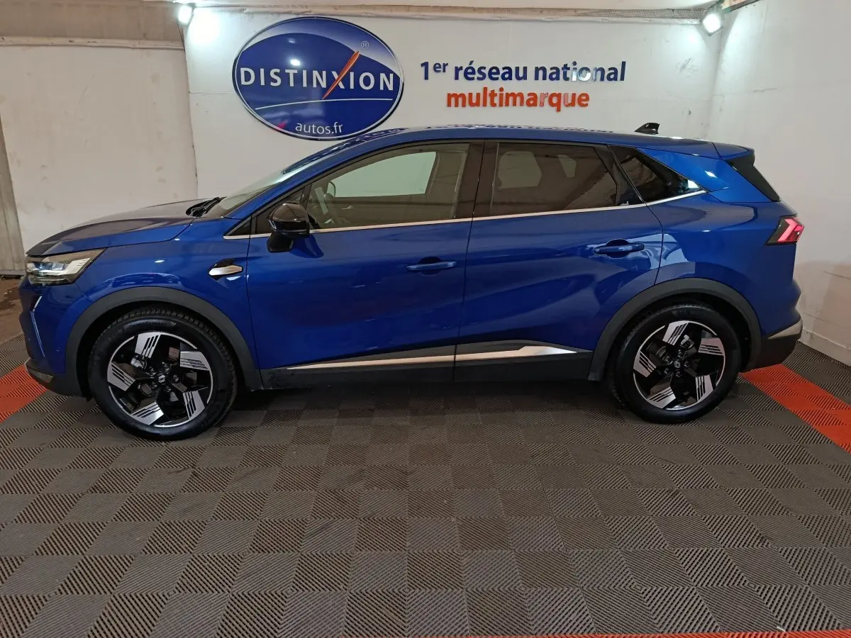 Renault SYMBIOZ bleu en profil droit dans un showroom, soulignant ses jantes noires et détails chromés.