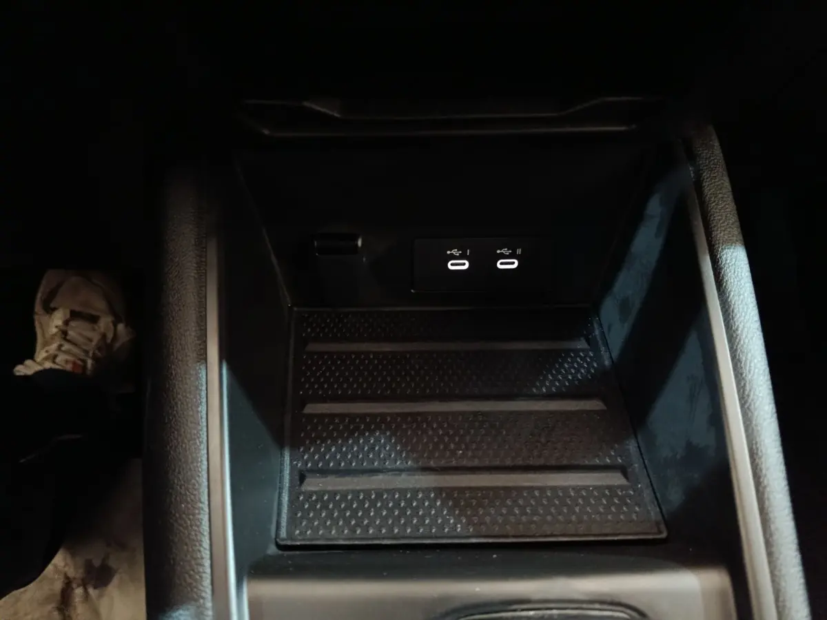 Gros plan sur la console centrale noire du Renault Symbioz bleu, montrant deux ports USB éclairés.