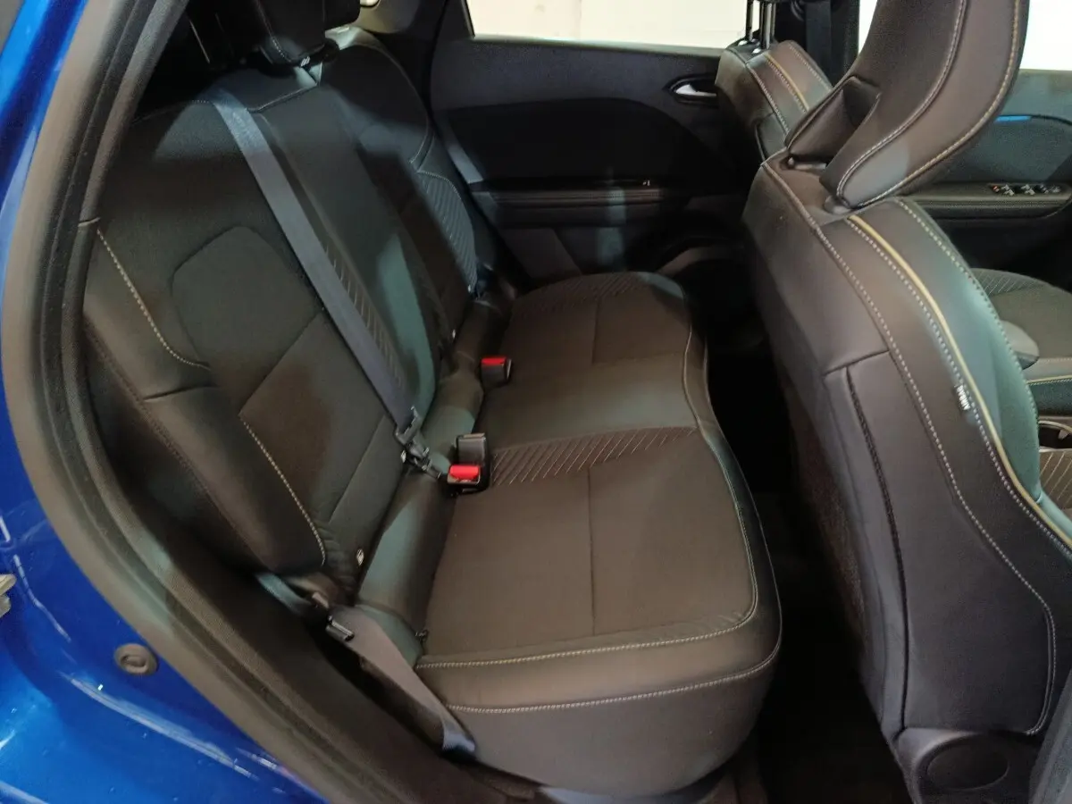 Vue côté gauche sur la banquette arrière noire du Renault SYMBIOZ bleu, avec ceinture de sécurité et détails de couture visibles.
